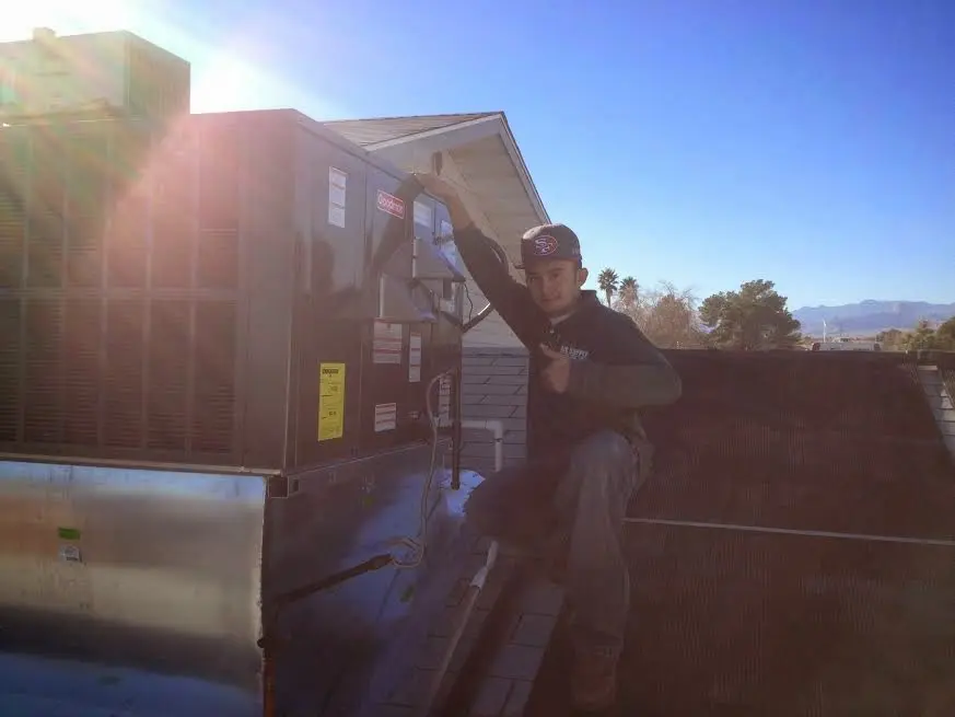HVAC technician performing HVAC Inspection on a rooftop unit in Sumter